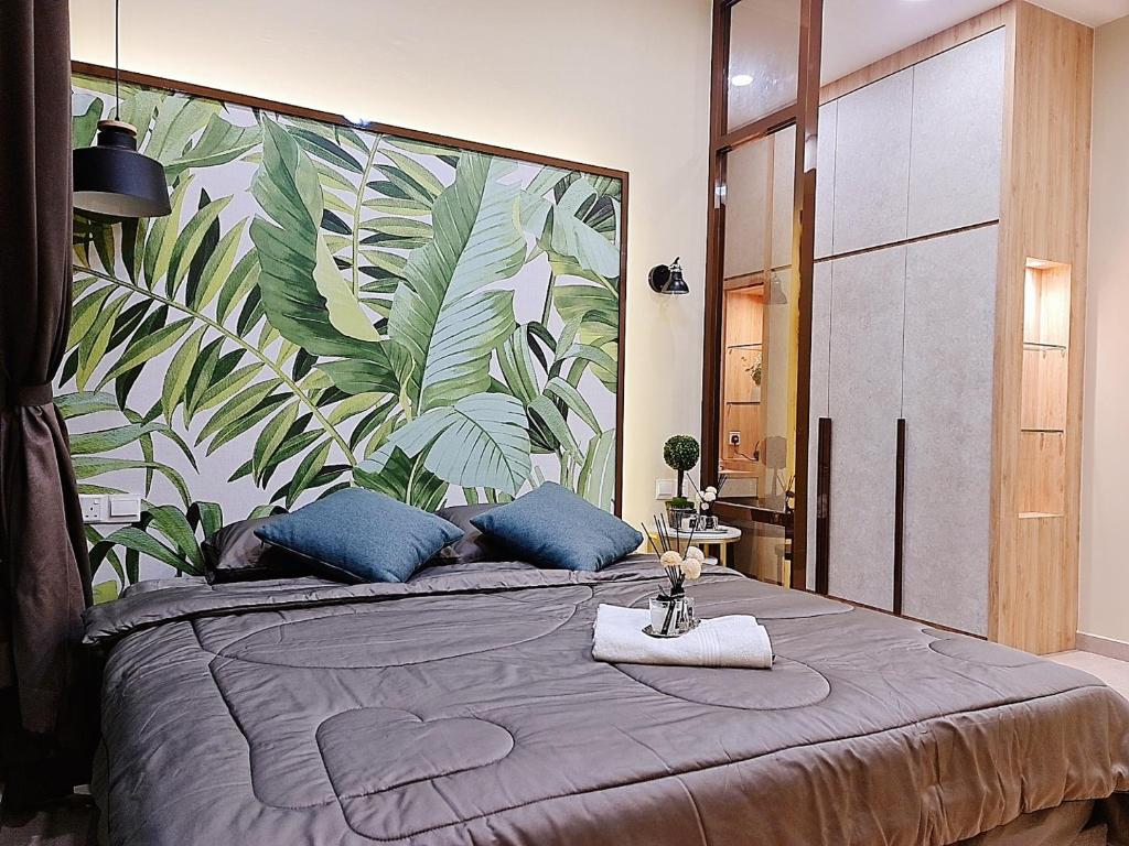 a bedroom with a large bed with a large leaf mural at NEW Condo Atlantis Melaka Town @ Memories in Melaka