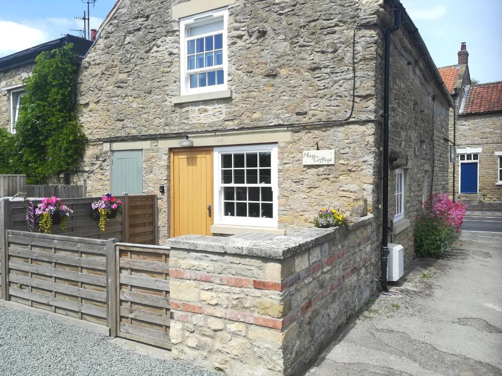 a stone house with a yellow door on a street at May Cottage in Scarborough