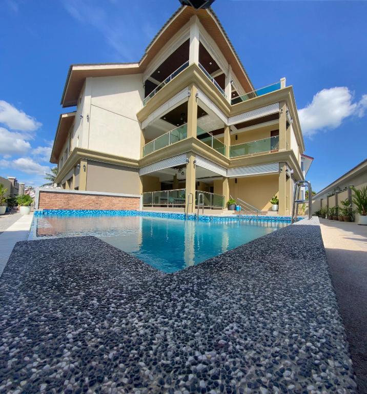 a house with a swimming pool in front of it at Grand Village Inn in Pantai Cenang
