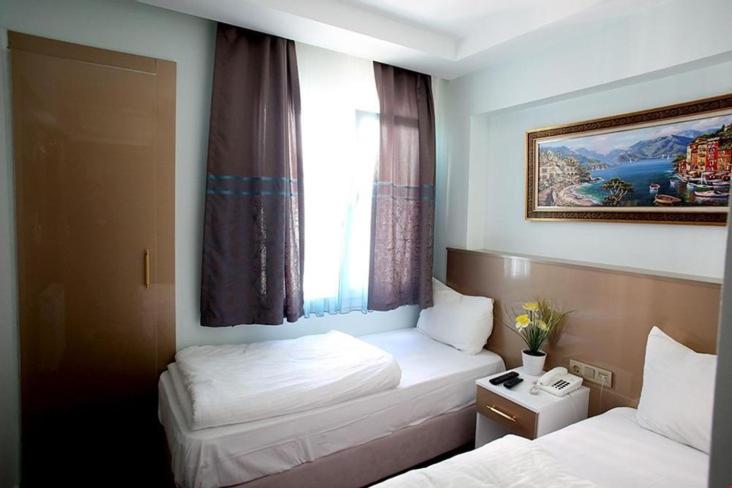 a hotel room with two beds and a window at Metrolux Hotel in Istanbul