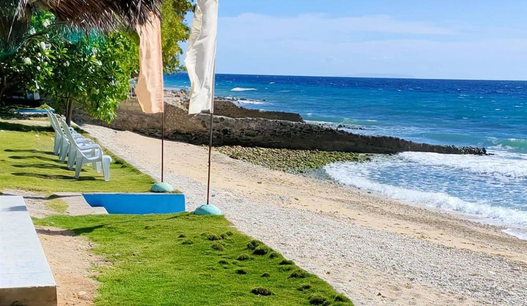 una playa con una silla blanca y el océano en Aloha, en Oslob