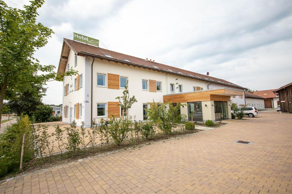 a white building with a fence in front of it at Hotel Donau-Ries in Mertingen