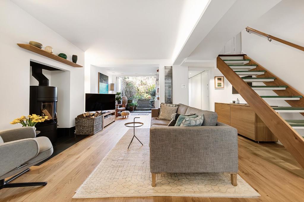 a living room with a staircase and a couch at Veeve - A Splash of Colour in London