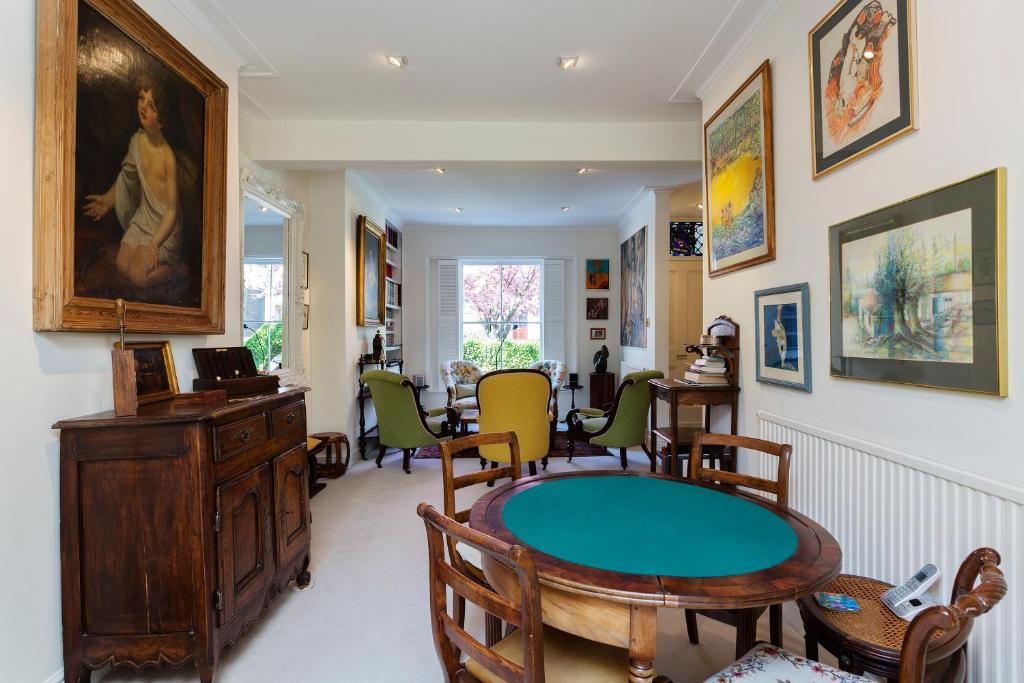 ein Wohnzimmer mit einem Tisch und Stühlen in der Unterkunft Veeve - The Gallery of Colour in London