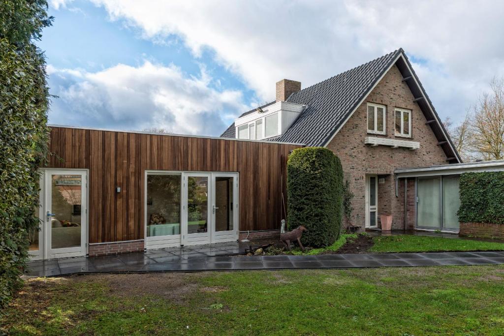 a house with a wooden facade with a yard at Right Garden Suite in Villa near Centre and TUe in Eindhoven