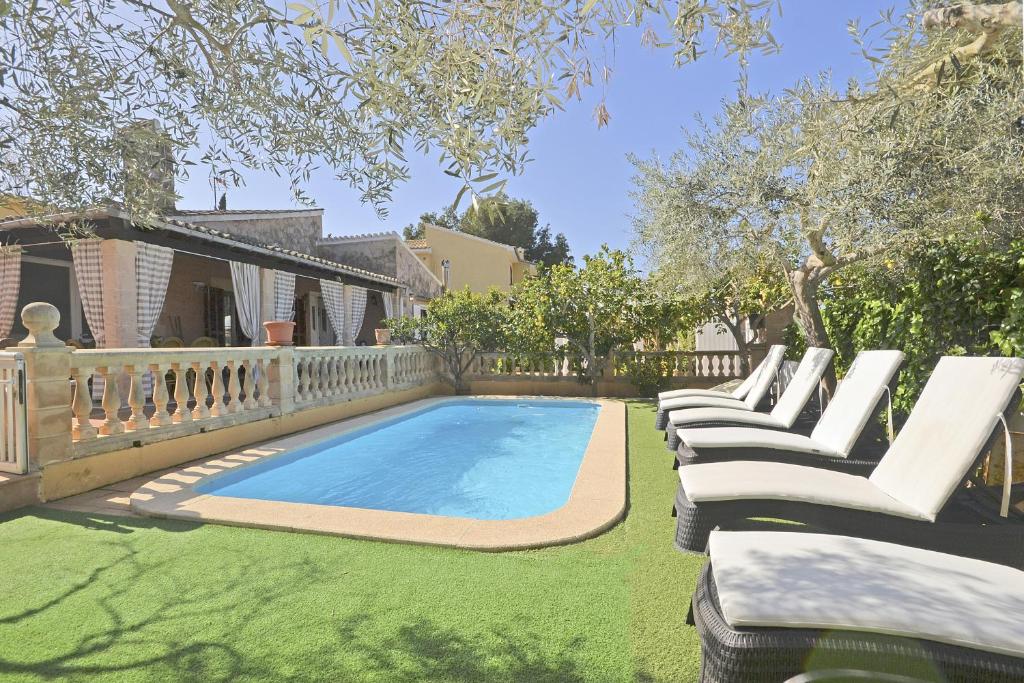 a row of lounge chairs next to a swimming pool at Villa Llimona in Alcudia