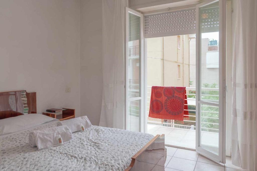 Schlafzimmer mit einem Bett und einer Glasschiebetür in der Unterkunft Family Room Casa Vacanze in Marcelli