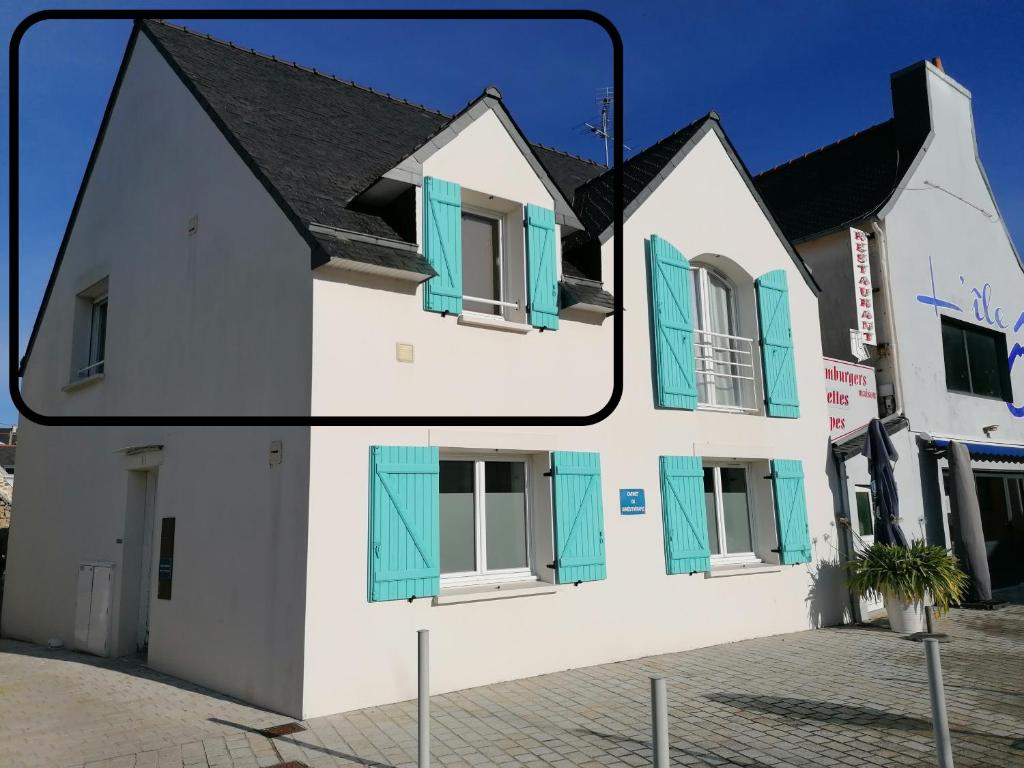 een wit gebouw met blauwe luiken erop bij Le Dixmude, appartement proche plage de Morgat in Crozon