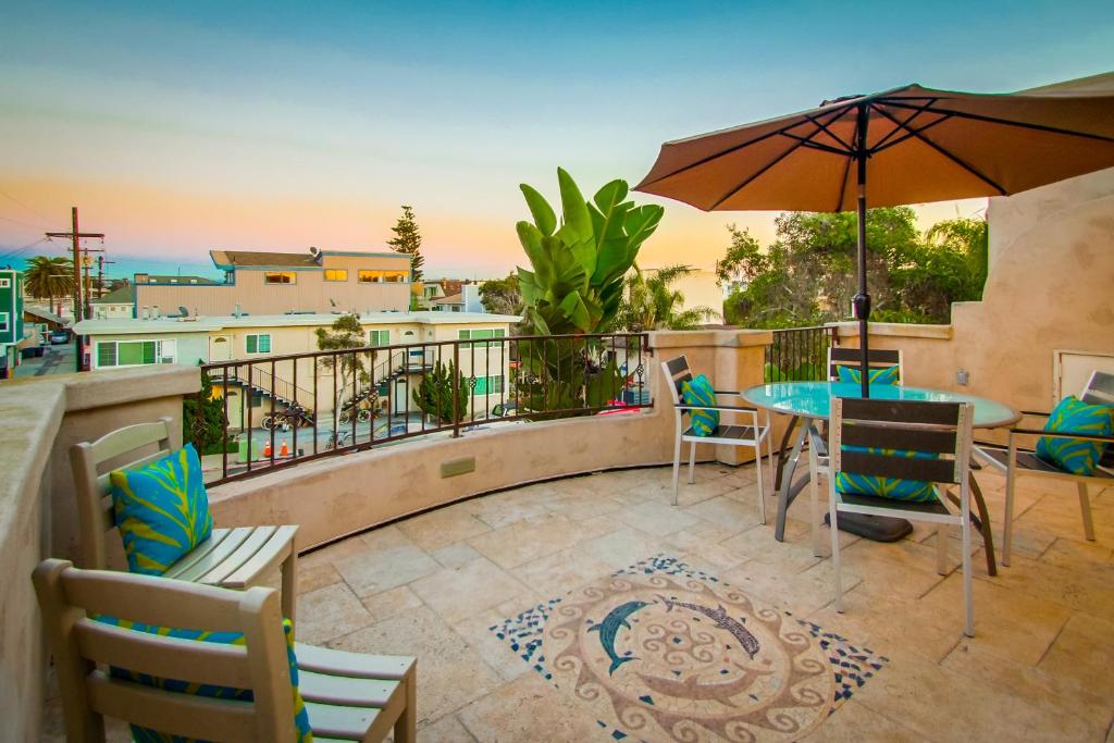 a balcony with a table and chairs and an umbrella at Devon Getaway in San Diego