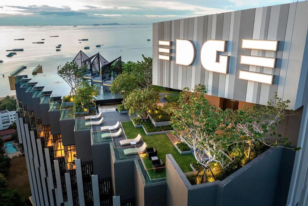 een uitzicht op een gebouw met stoelen en bomen bij Edge Central Pattaya by J&P in Pattaya