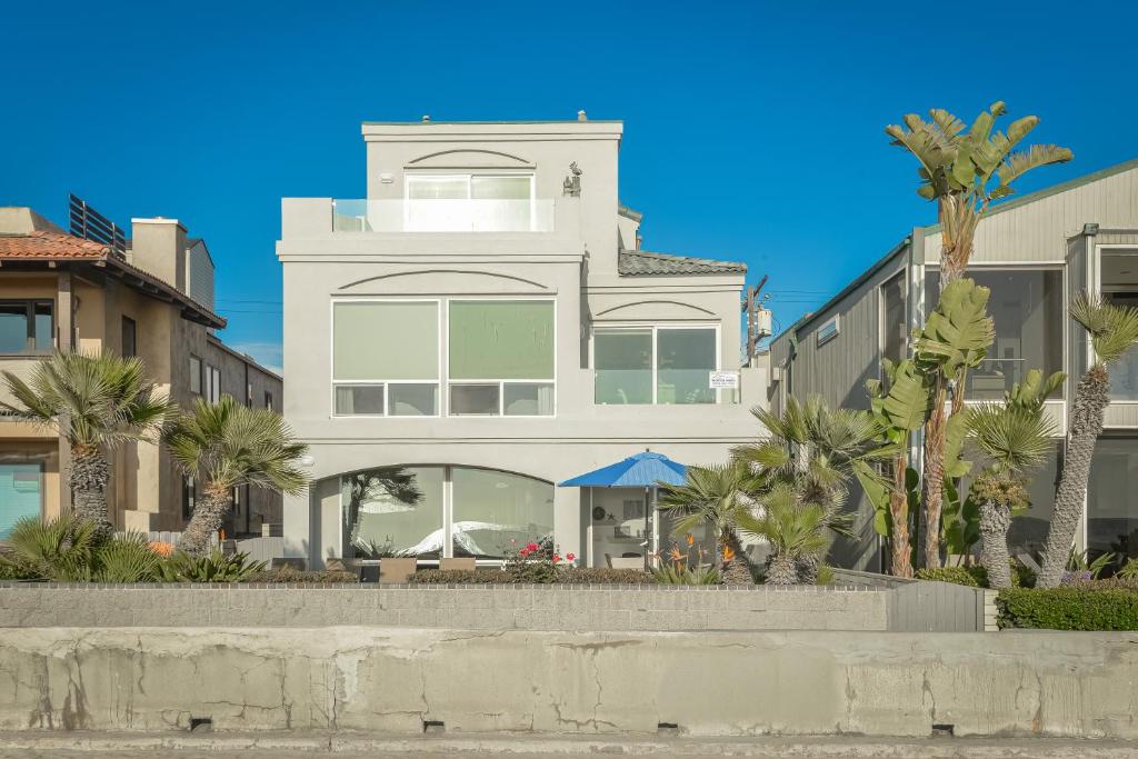 a white building with palm trees in front of it at Brighton Bungalow in San Diego