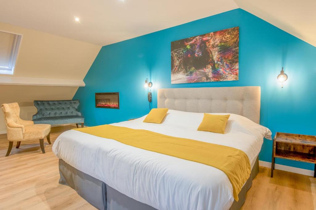 1 dormitorio con 1 cama grande y pared azul en Castello en Pierrefonds