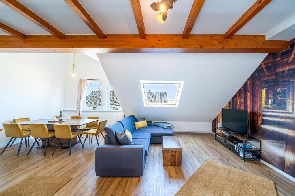 ein Wohnzimmer mit einem blauen Sofa und einem Tisch in der Unterkunft Stylisches Penthouse zentral Tischfussball 100m2 Wii in Hannover