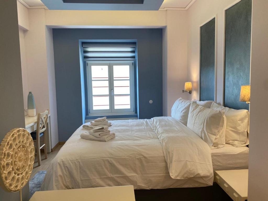 - une chambre avec un grand lit blanc et une fenêtre dans l'établissement HOTEL TSARSI, à Kastoria