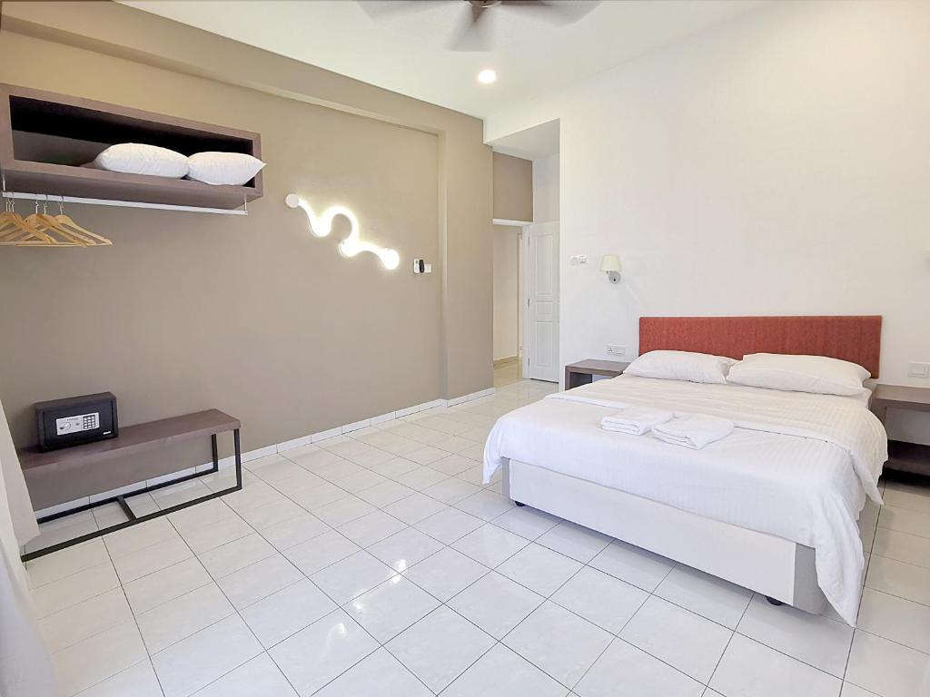 a bedroom with a white bed and a white tile floor at 3 Concordia @ Gurney in George Town