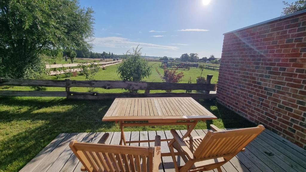 una mesa de picnic y 2 sillas en una terraza de madera en Ferienwohnung Rügen 2, Alt Reddevitz 108, Insel Rügen, Sauna Nutzung möglich, en Alt Reddevitz