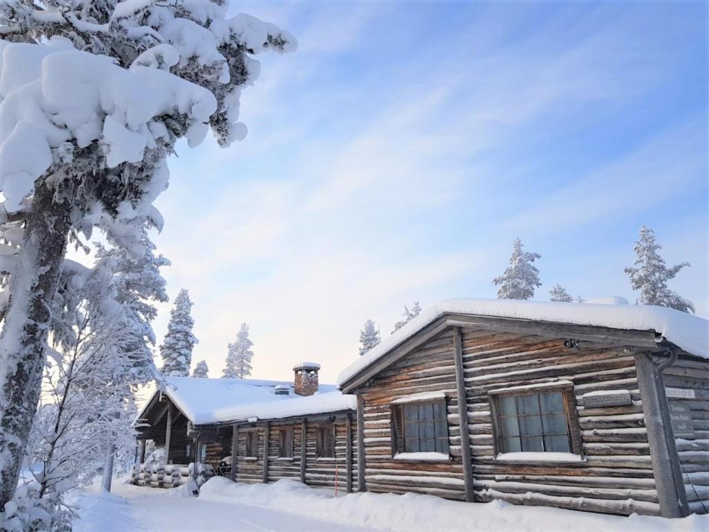 une cabane en rondins dans la neige dans l'établissement Tunturipöllö / Lapland, Saariselkä, à Saariselka