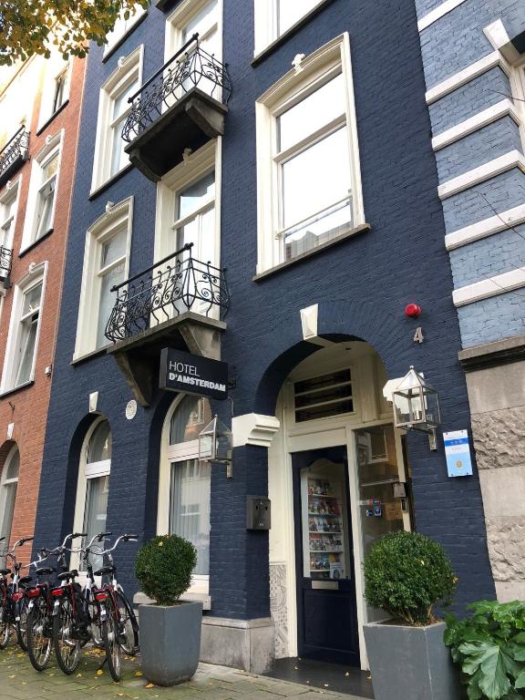 un edificio blu con biciclette parcheggiate fuori di Hotel D'Amsterdam Leidsesquare ad Amsterdam