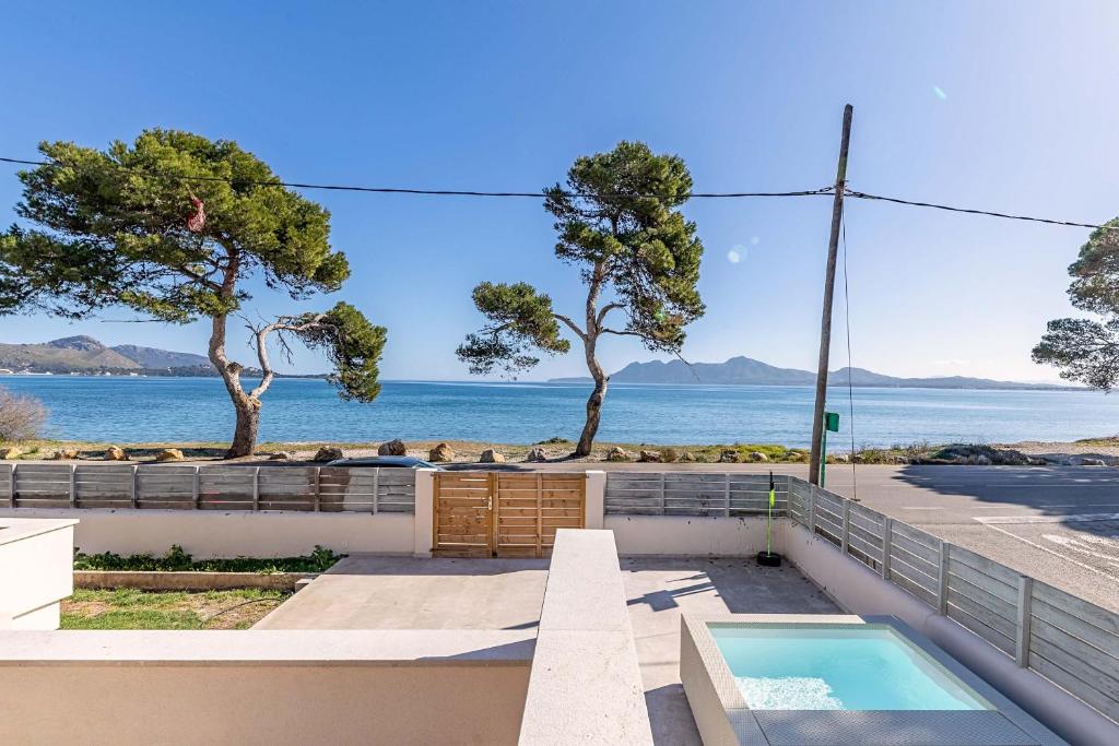 a house with a swimming pool and a view of the ocean at Seafront Villa Mar i Pins by Sealand Villas in Port de Pollensa
