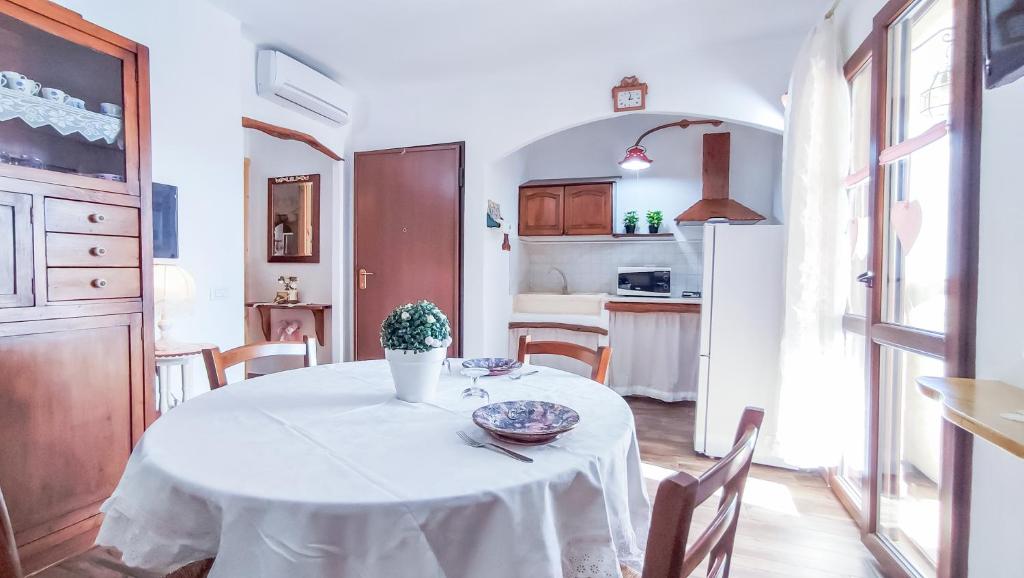 a white table with a vase on it in a kitchen at S'Arrosa de Monti in Villaputzu