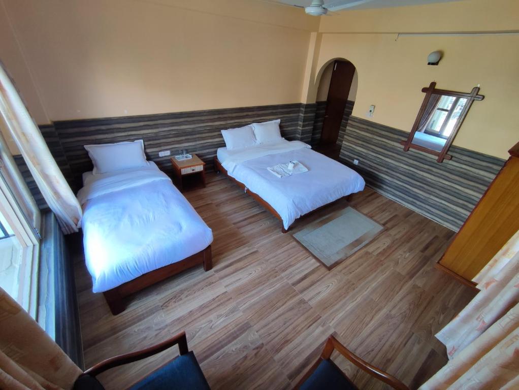een slaapkamer met 2 bedden aan de bovenkant bij The Mountain House in Pokhara