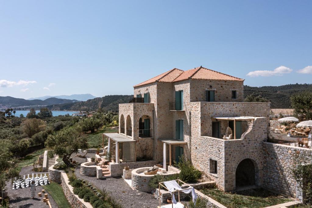 uma antiga casa de pedra com vista para a água em The Olive Yard em Gytheio