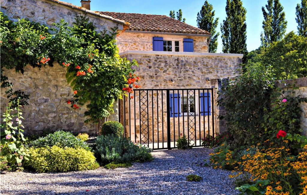 una antigua casa de piedra con una puerta en un jardín en Mas Chazel, en Lussan