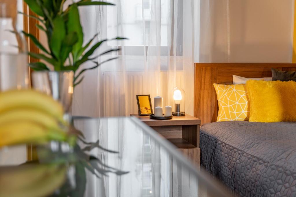 a bedroom with a bed and a table with a plant at Penzion Expo Dream #33 by goodnite cz in Brno