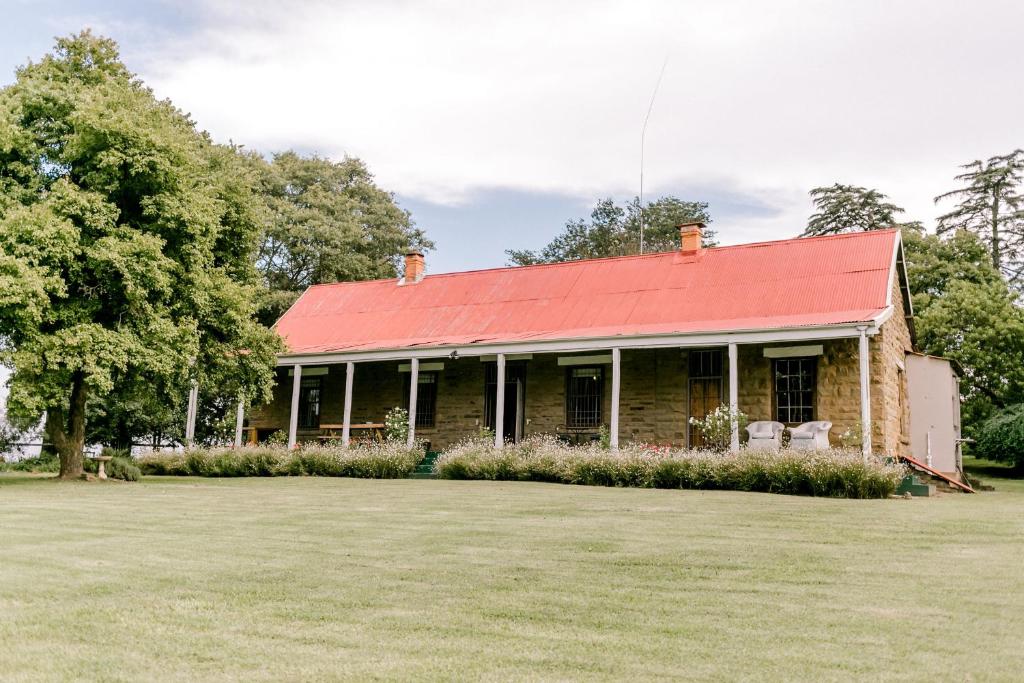 Henburg Park的住宿－Crompton Cottage，一座红屋顶的老砖房