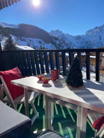 stół z choinką na balkonie w obiekcie STUDIO 2 ALPES STYLE CHALET au PIED DE TELESIEGE DU DIABLE w mieście Les Deux Alpes