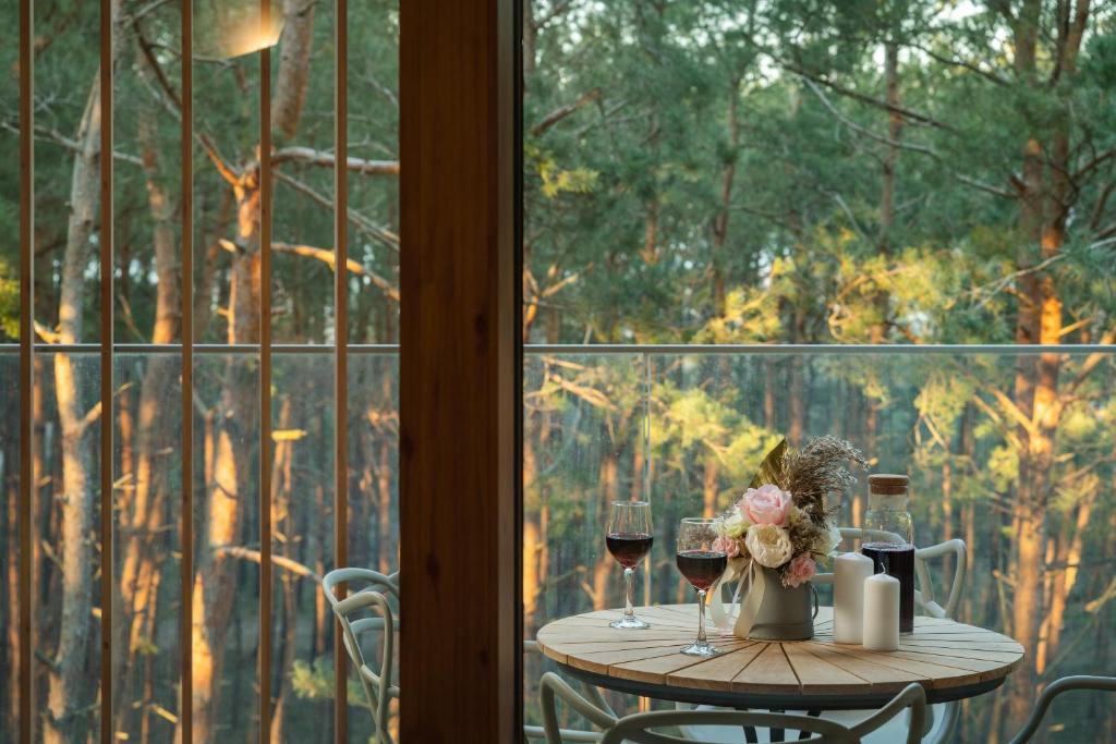 a table with two glasses of wine and flowers at Apartamenty In - Władysławowo in Władysławowo