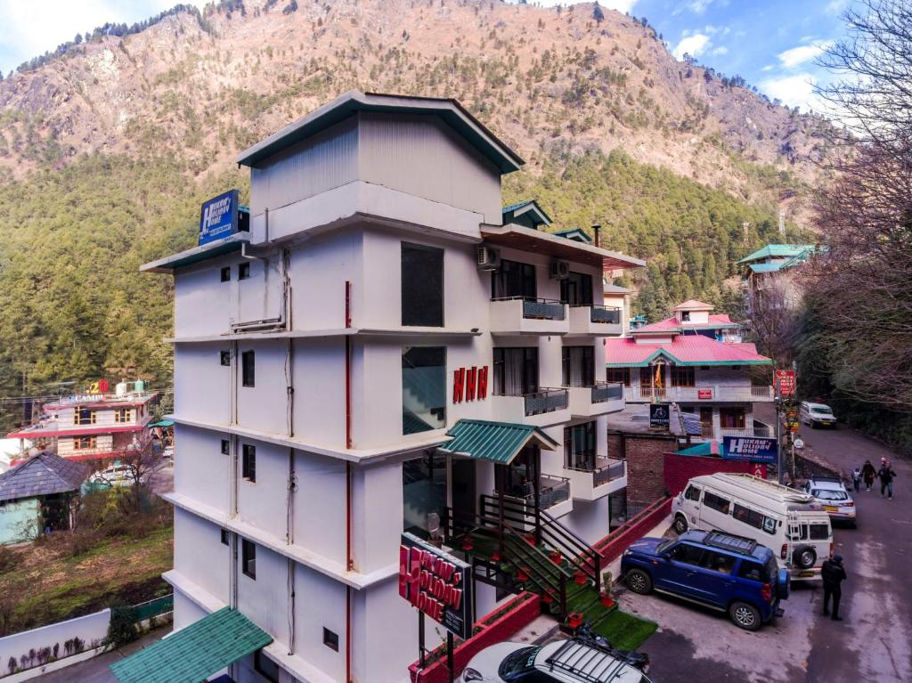 a building on a street with a mountain in the background at Hukam's Holiday Home in Kasol