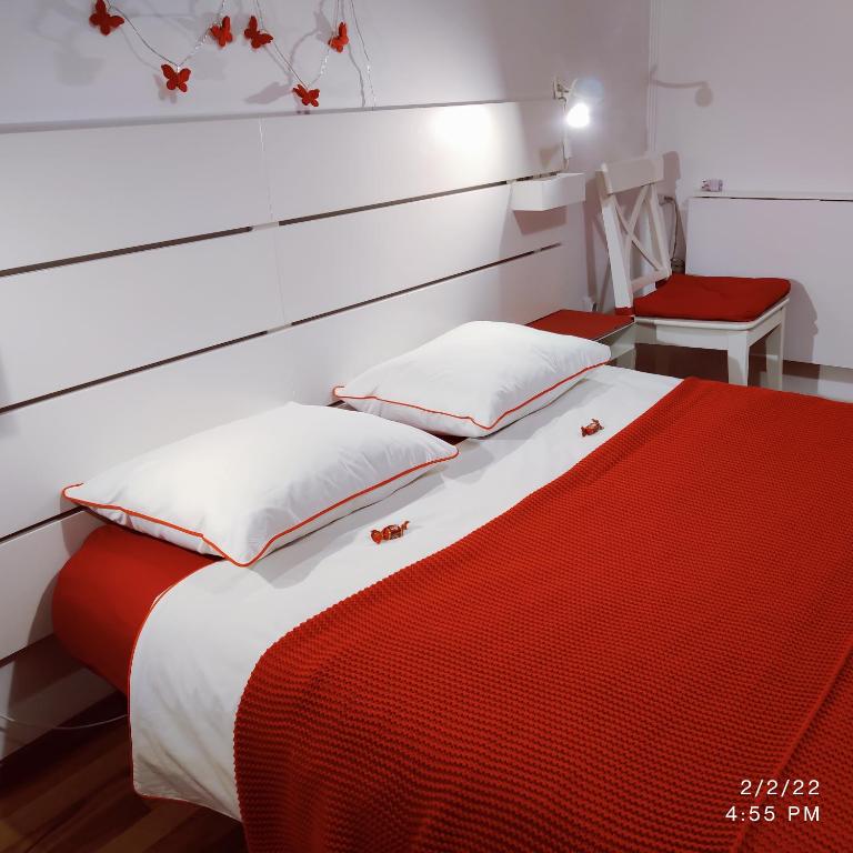 a bedroom with a red and white bed with a headboard at WhiteHouse in Popeşti-Leordeni