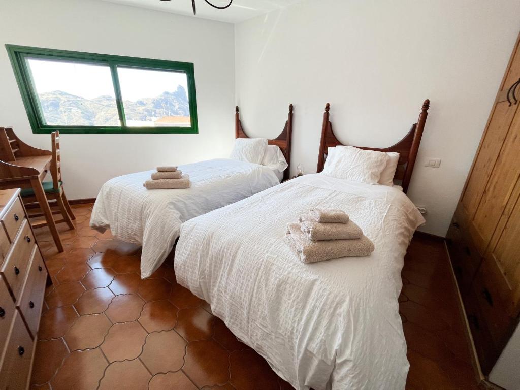 - 2 lits dans une chambre avec des serviettes dans l'établissement Central House at Tejeda's Heart with Amazing View, à Tejeda