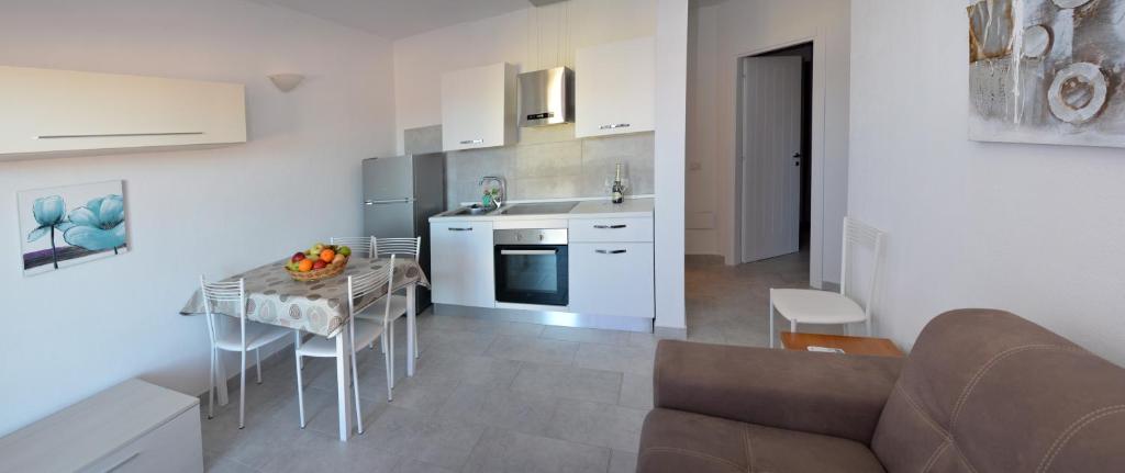 eine Küche mit einem Sofa und einem Tisch in einem Zimmer in der Unterkunft Residence Eolo in Porto Pozzo