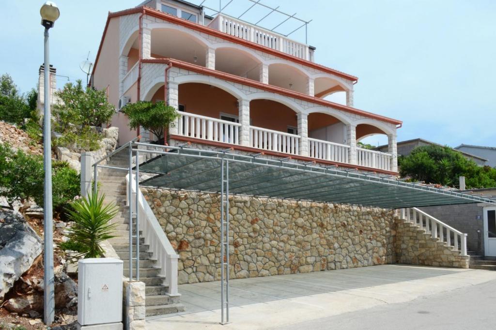 Apartment in Prizba with sea view, balcony, air conditioning, WiFi 5080-1 في كورتْشولا: مبنى مع شرفة فوق جدار حجري