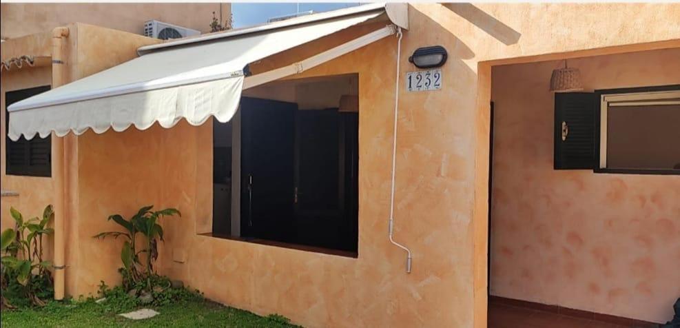 a house with an awning on the side of it at Home Beach Costa Rey in Costa Rei