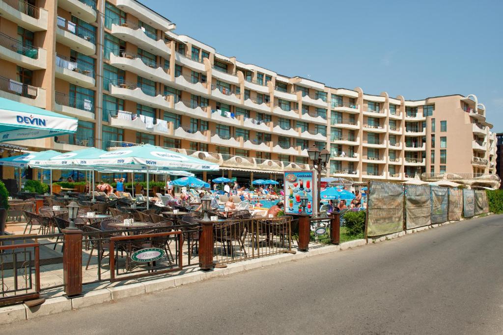 サニービーチにあるApartments in Grenadaの建物の前にテーブルと傘を用意したホテル