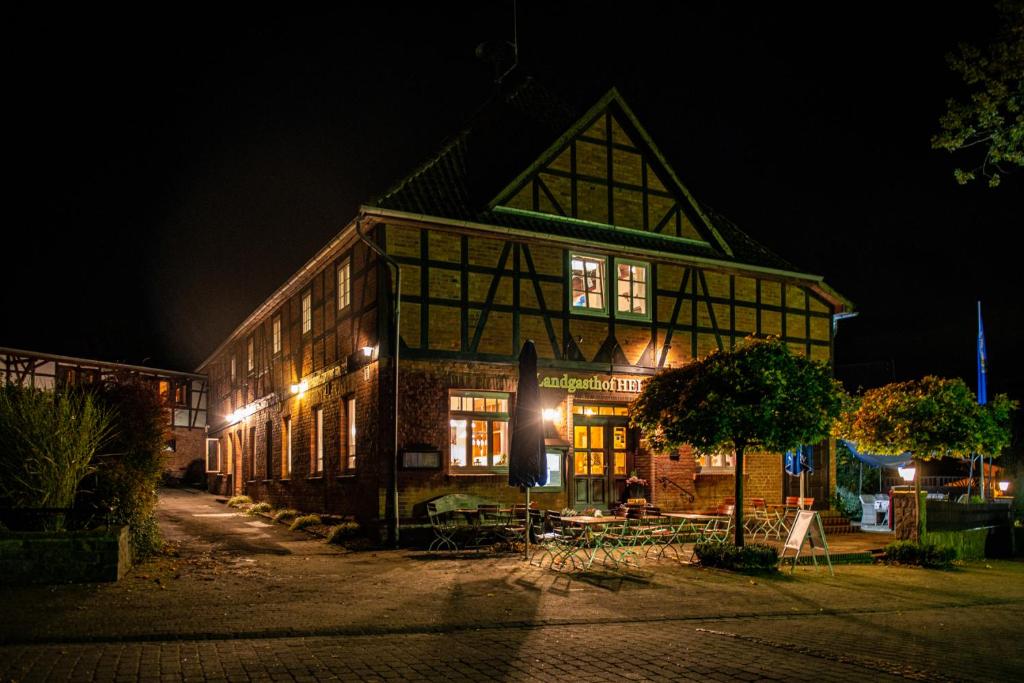 ein großes Gebäude in der Nacht mit eingeschaltetem Licht in der Unterkunft Landgasthof Heidetal in Betzendorf