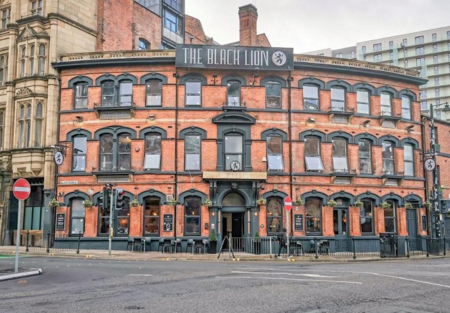 a large red brick building with a sign on it at Black Lion Hotel in Manchester