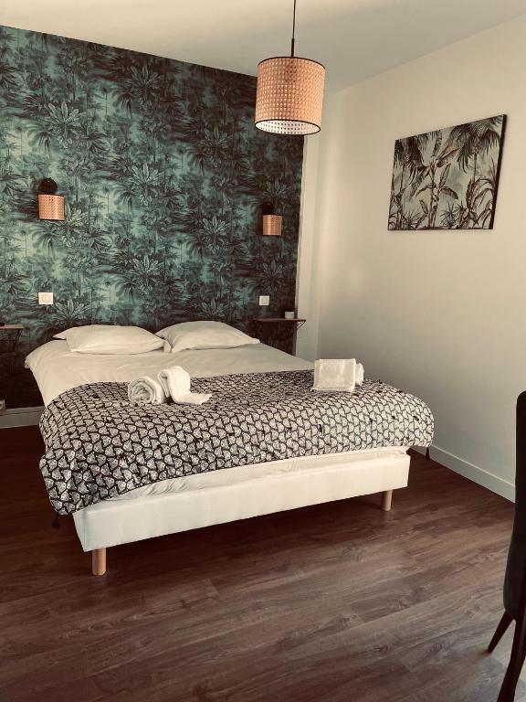 a bedroom with a bed with a green wall at logis Paul Massy in Meschers-sur-Gironde