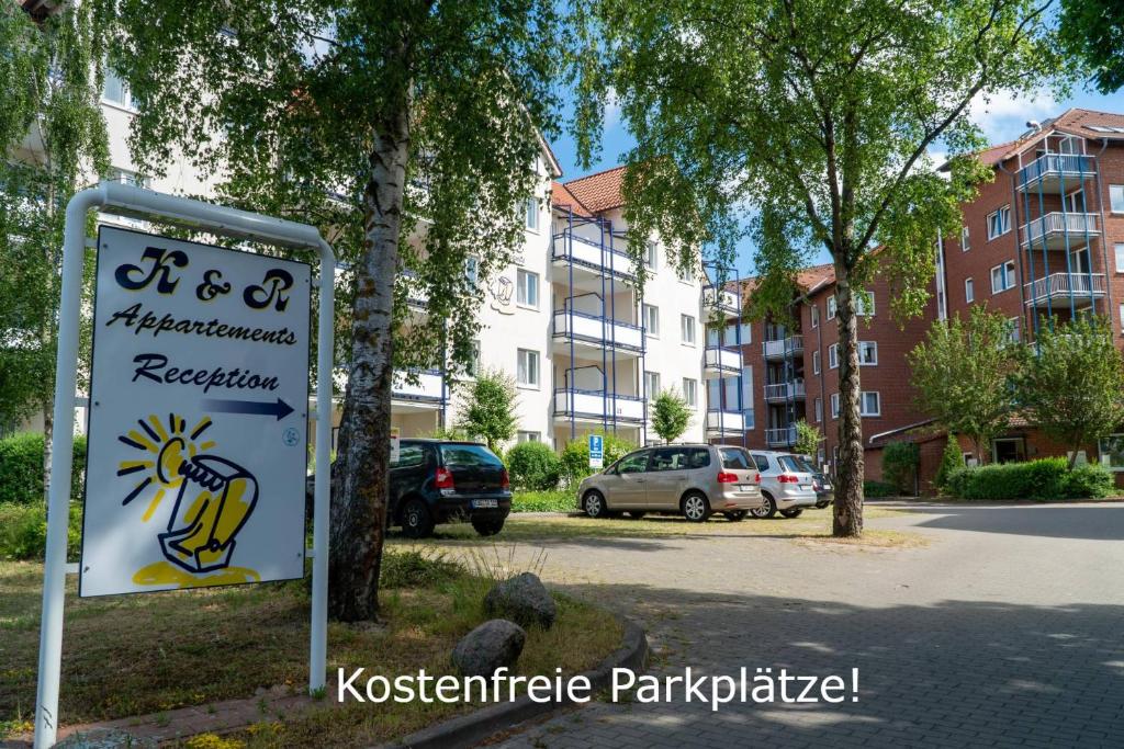 a sign in front of a parking lot with buildings at K & R Appartements Binz in Binz