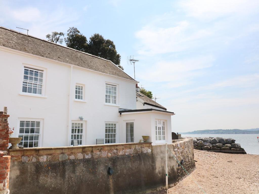 a white house on the shore of the water at Searles in Lympstone