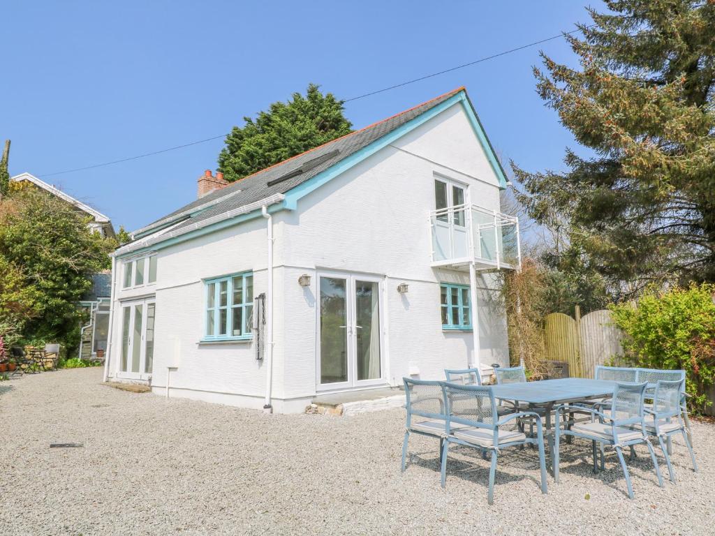 a white house with a table in front of it at Scott's Cottage in Helston