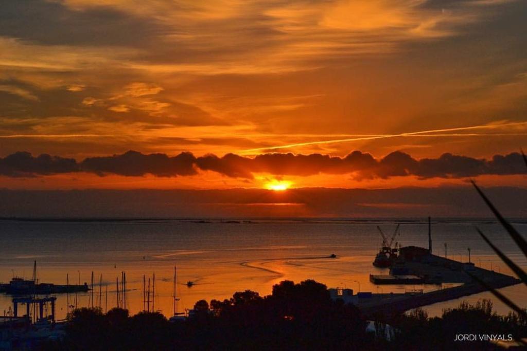 a sunset over a body of water with boats at Ático de lujo con vistas al mar in Sant Carles de la Ràpita
