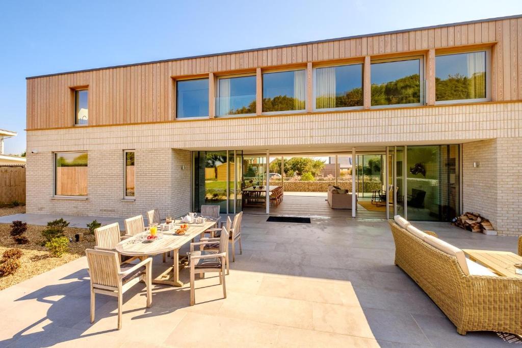 a patio with a table and chairs in front of a building at Heath House in Thorpeness