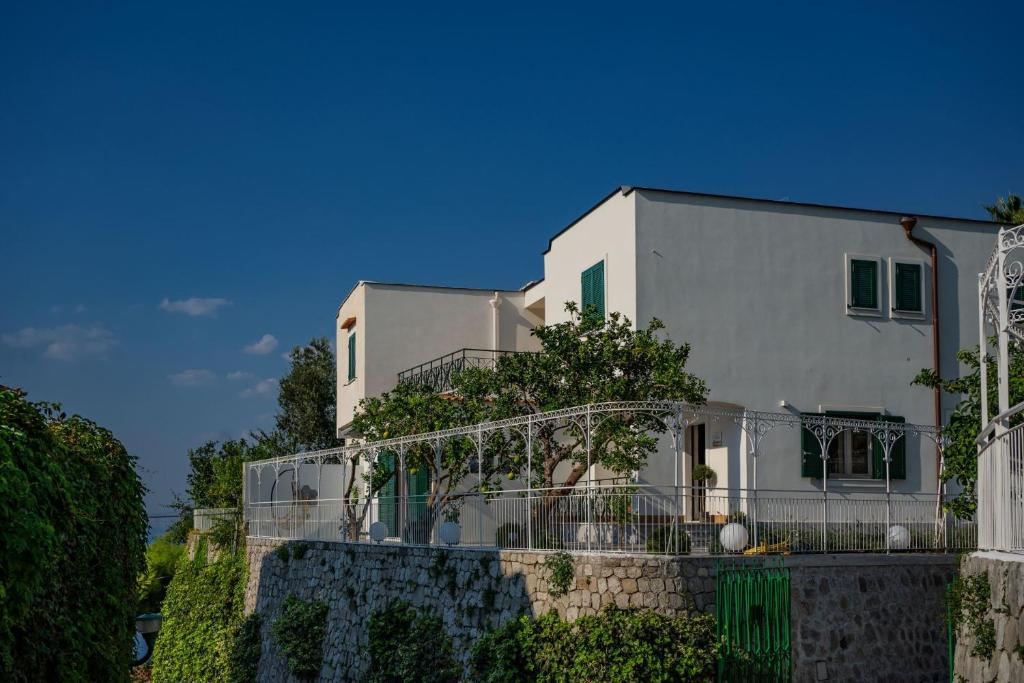 een wit huis met een hek ervoor bij Villa La Pagaia Sorrento Coast in Vico Equense
