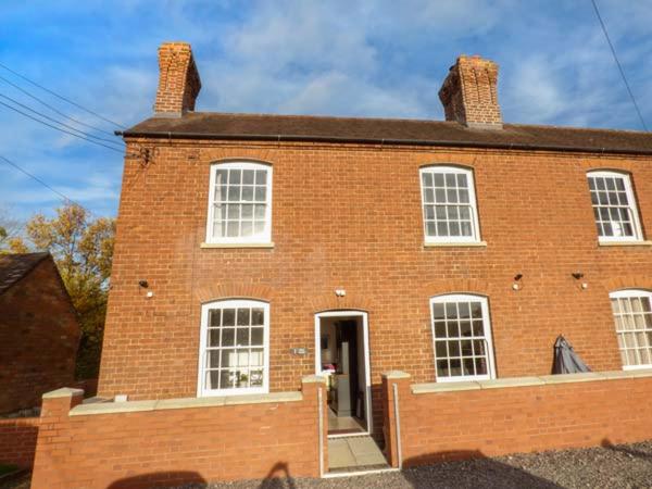 una casa in mattoni rossi con porta e finestre di 1 Willow Cottage a Upton-upon-Severn