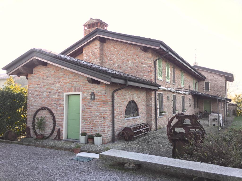 a brick house with a green door on a street at da Luigi al Mulino in Annicco