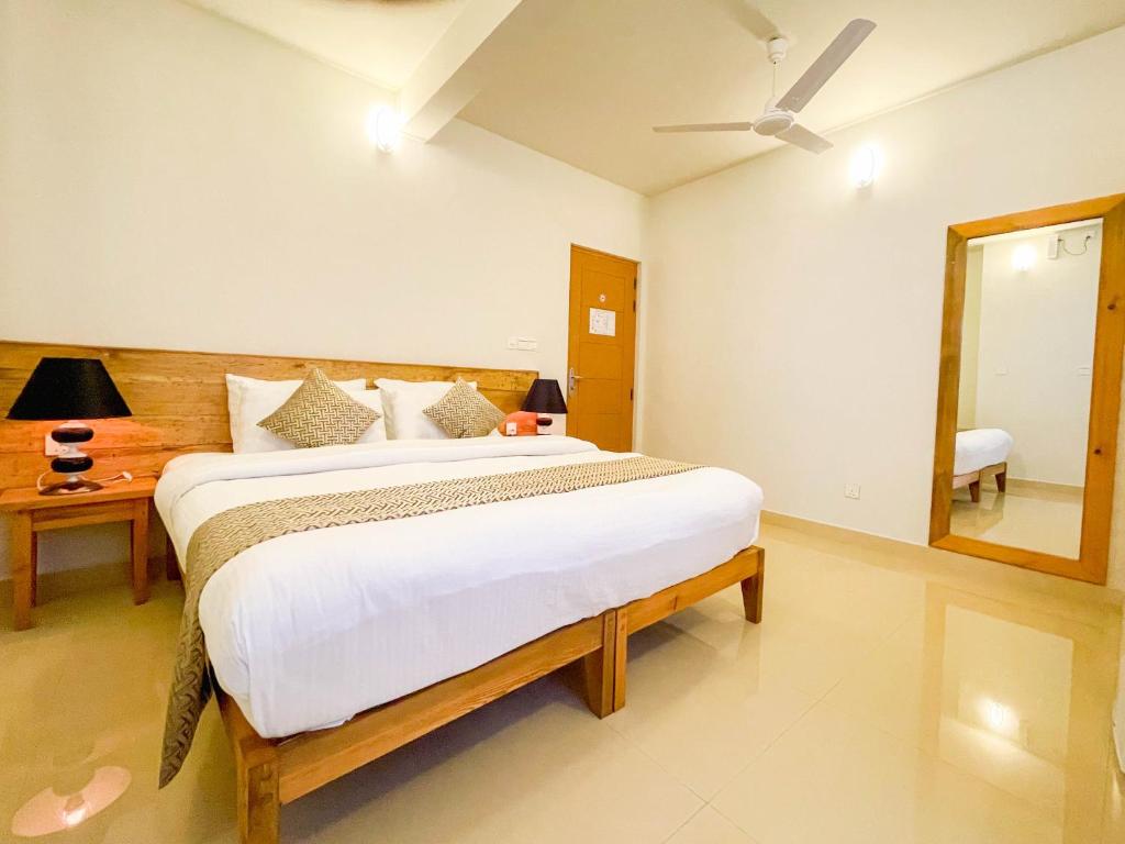 a bedroom with a large bed and a mirror at Suffix Retreat - Stay, Dive & Explore Fuvahmulah in Fuvahmulah